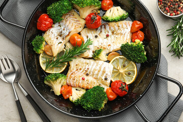Tasty cod cooked with vegetables served on grey table, flat lay