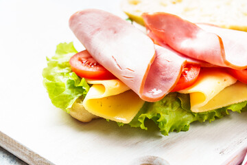 Sandwich with lettuce, cheese, tomatoes and ham. Healthy fast food or snack. Close up. - 783196437