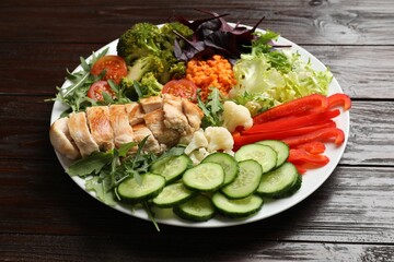 Balanced diet and healthy foods. Plate with different delicious products on wooden table