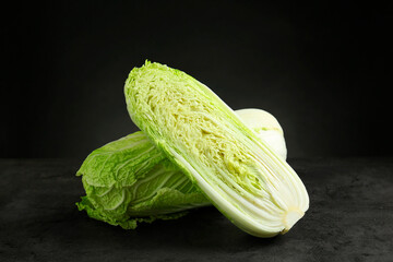 Whole and cut fresh Chinese cabbages on grey table