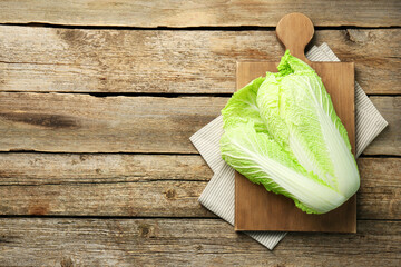 Fresh ripe Chinese cabbage on wooden table, top view. Space for text - obrazy, fototapety, plakaty