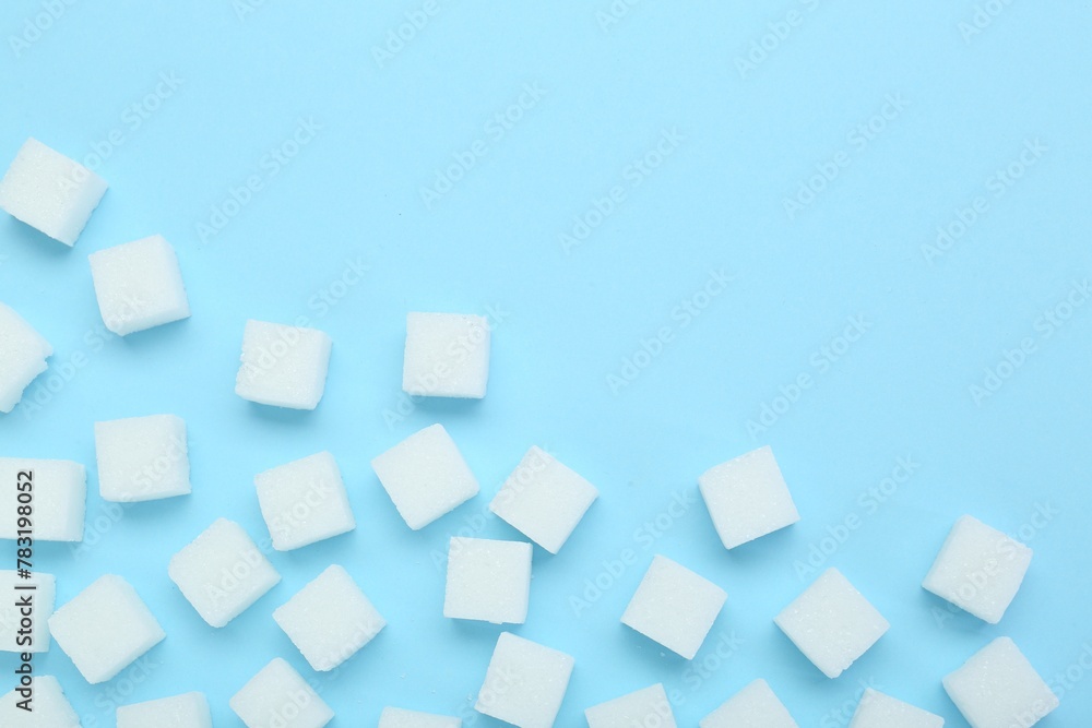 Poster white sugar cubes on light blue background, top view. space for text