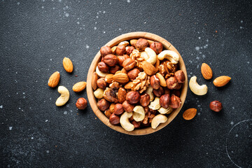 Nuts assortment at black background. Almond, hazelnut, cashew in wooden bowl. - 783200427