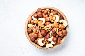 Nuts assortment at white background. Almond, hazelnut, cashew in wooden bowl.