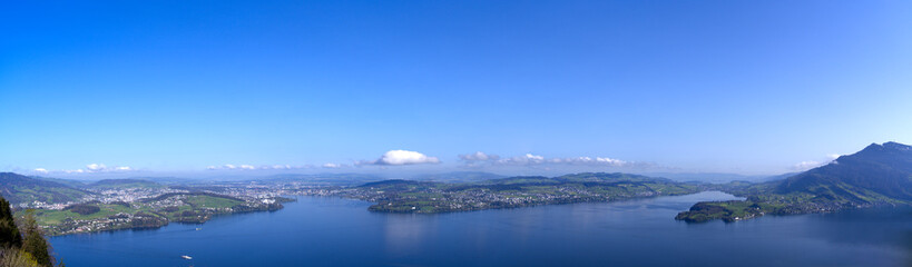 Wide angle panoramic view over Swiss Lake Lucerne seen from viewpoint Bürgenstock at Swiss alp on a sunny spring morning. Photo taken April 11th, 2024, Ennetbürgen, Switzerland.
