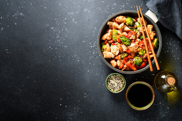 Chicken stir fry with soy sauce and vegetables at black background. Flat lay with copy space. - 783203823