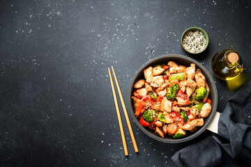 Stir fry chicken and vegetables and sesame at black background. Asian cuisine. Top view with space for design. - 783204001
