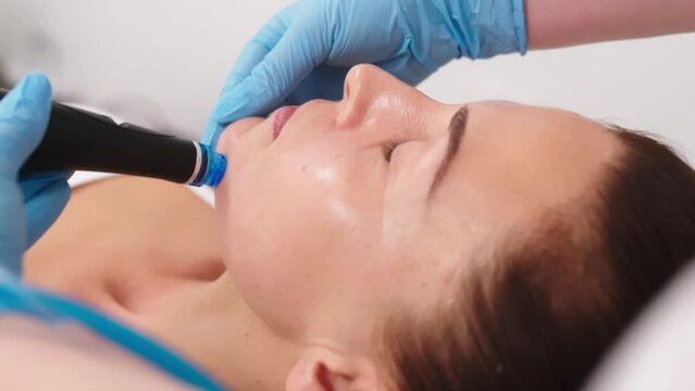 Middle aged woman receiving hydro facial lifting procedure. Natural, mature woman face with healthy freckle skin texture. Aesthetic, facial and skincare cosmetology