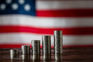 Money towers on the American flag background, closeup. Finance, business, investment and money saving concept