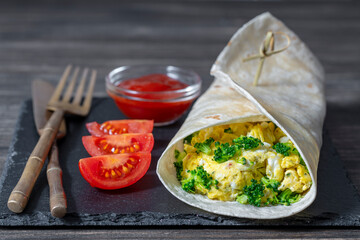 Homemade burrito wraps with scrambled egg omelet and microgreens for healthy breakfast on wooden board, closeup - 783215683