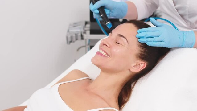 Middle aged woman receiving hydro facial lifting procedure. Natural, mature woman face with healthy freckle skin texture. Aesthetic, facial and skincare cosmetology