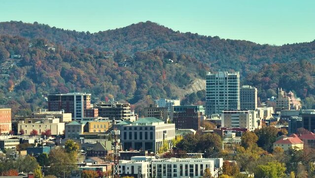Asheville city in North Carolina with high buildings and mountain hills in distance