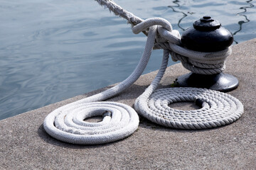 Flaked lines by the waters edge with a mooring line wrapped around it and flaked on the dock

