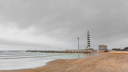 Jesolo's beach on a cloudy morning with its lighthouse at the end of it