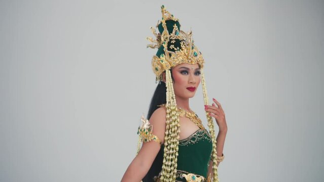 Woman in traditional Javanese dance costume with golden headdress.