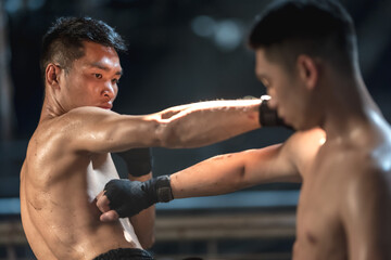 Portrait Muay Thai boxer men punching to each other doing Thai boxing competition  