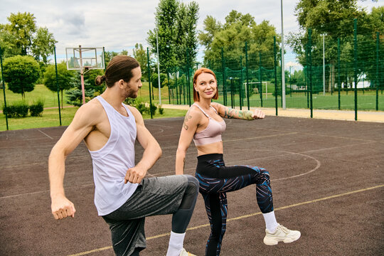 A determined woman in sportswear stand on a basketball court, guided by a personal trainer, exhibiting motivation. - Powered by Adobe