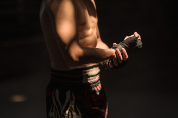 Close up Thai boxer man with black boxing bandage guarding and ready to fight