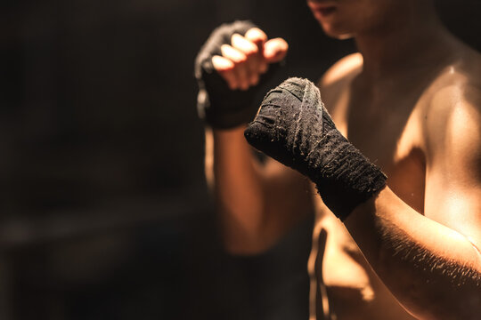 Close up Thai boxer man with black boxing bandage guarding and ready to fight