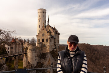 Attractive mature traveler in front of the famous Liechtenstein Castle near Honau