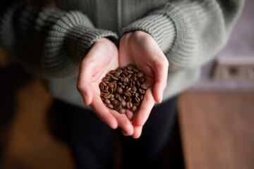 Close-Up View of a Pair of Hands Gently Holding Fresh Coffee Beans