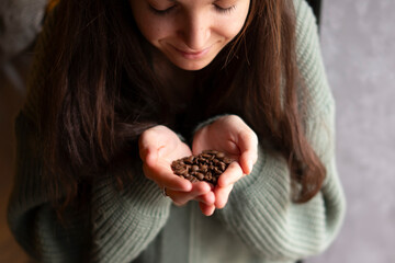 Close-Up View of a Pair of Hands Gently Holding Fresh Coffee Beans