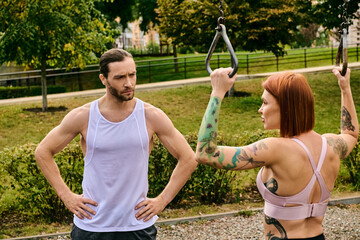 woman in sportswear train together with a personal trainer in a park, showcasing determination and...