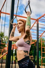 Foto op Canvas A determined woman in sportswear is doing a pull up on a bar outdoors © LIGHTFIELD STUDIOS