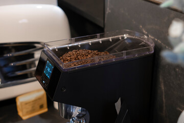 Close-Up View of Roasted Coffee Beans in a Grinder Machine at a Local Café