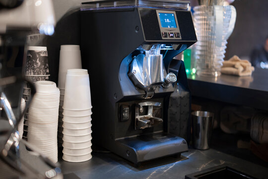 Close-Up View of Roasted Coffee Beans in a Grinder Machine at a Local Café