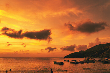 Landscape with beautiful sunset on the sea and boats on the shore. Taganga Beach. Santa Marta,...