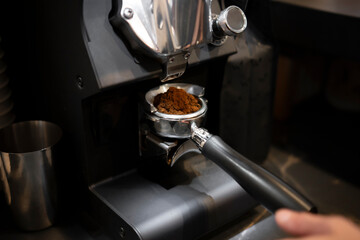 Barista Precisely Measures Ground Coffee for Espresso in a Portafilter at a Modern Cafe