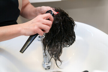 Close-up of adjustment to a wet hair system in a salon.