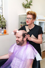 Client receives careful scalp cleaning after hairpiece removal.