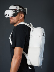 Portrait of man wearing augmented VR goggles with white backpack.