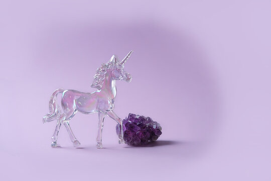 crystal unicorn and amethyst mineral on abstract violet background. Magic Crystal Ritual. Witchcraft, Esoteric spiritual practice for life balance, Relaxation