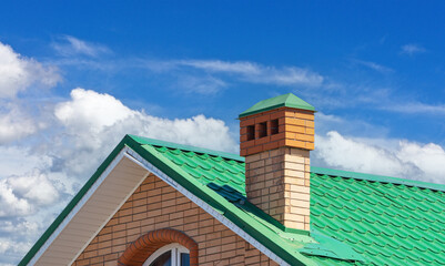 house with a roof from a green shingles with a pipe