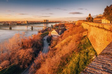 enchanting beauty of Novi Sad's skyline against the backdrop of the Danube River, showcasing the majestic fortress of Petrovaradin in the soft light - obrazy, fototapety, plakaty