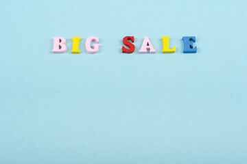 Big sale word on blue background composed from colorful abc alphabet block wooden letters, copy space for ad text. Learning english concept.