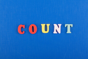COUNT word on blue background composed from colorful abc alphabet block wooden letters, copy space for ad text. Learning english concept. - obrazy, fototapety, plakaty