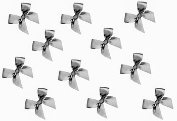 Gray bows on the white background. Pattern. Flat lay.