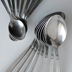 Different Size Spoons Laid Out In Form Of Fans On A Clean Plastic Cutting Board Closeup View
