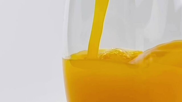 Close up pouring orange juice into Glass Isolated on White Background clipping path