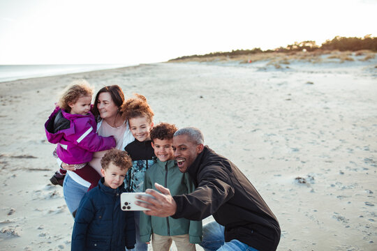 Young mixed family taking a selfie on the beach