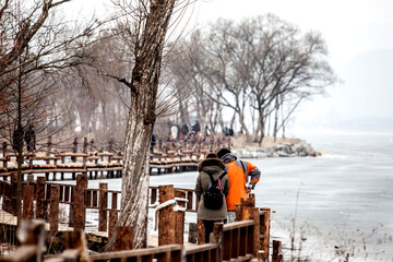 View of the tourists walking at the side of frozen river