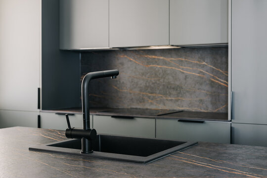 Black sink faucet in sober kitchen