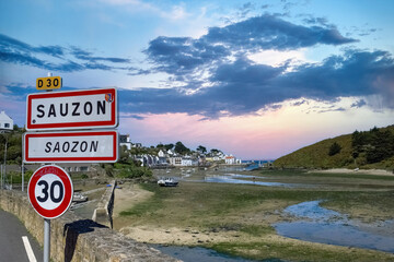 Sauzon in Brittany, the typical harbor with boats and lighthouse, and the town sign- 783274488