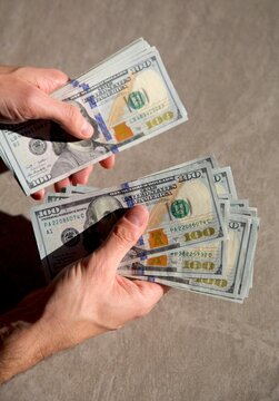 Counting a pile of hundred dollar bills closeup