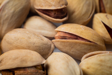 Many closed pistachios in macro close-up. Healthy food background with selective soft focus