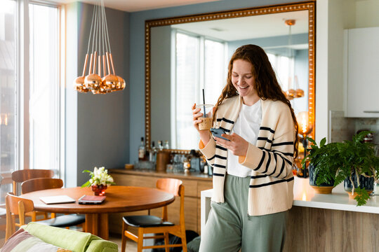 A woman uses a mobile phone at home